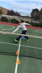 Preson hitting a tennis ball with tennis racket